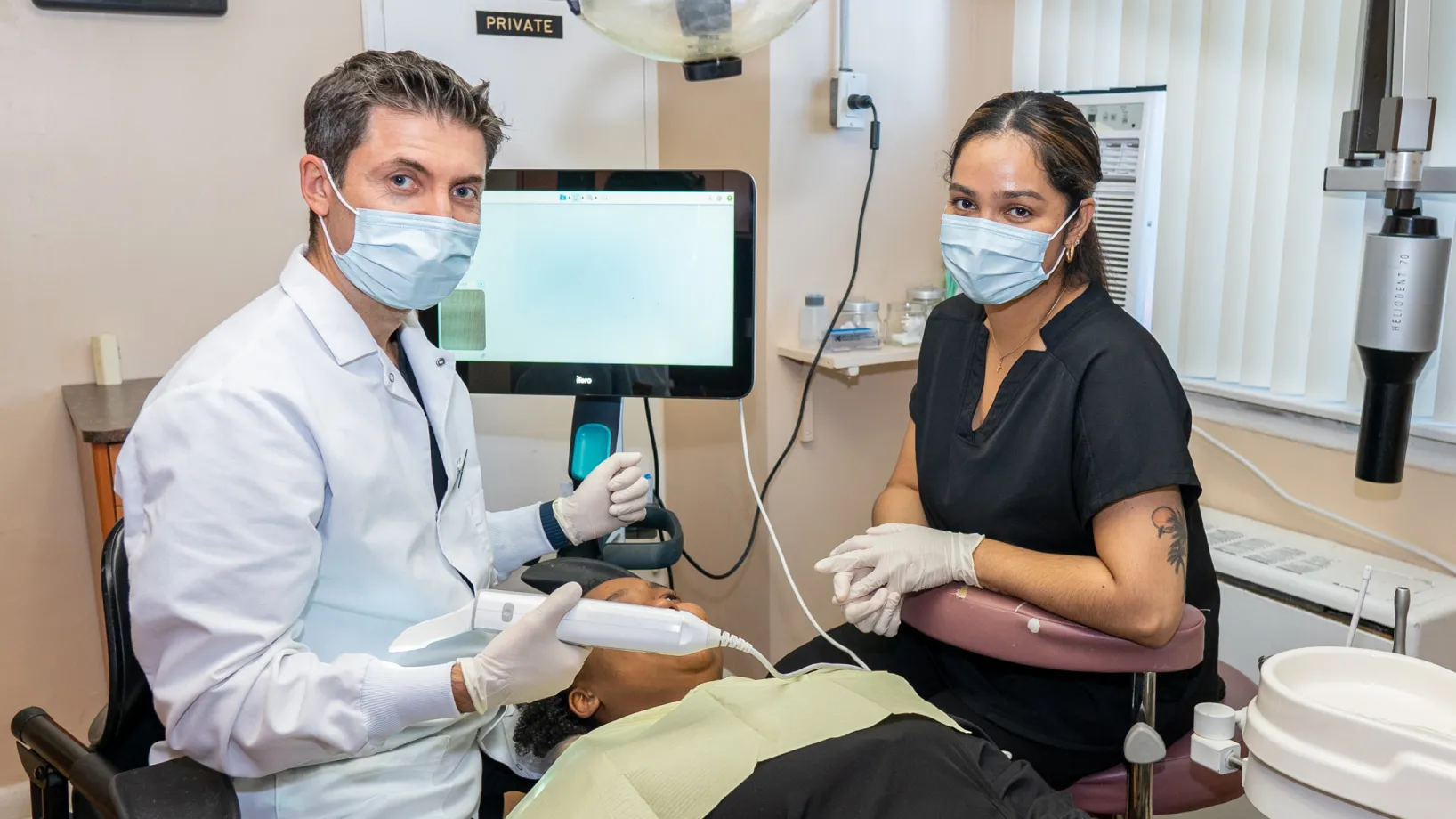 a man in a dentist chair with a woman in a mask